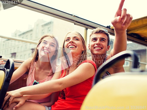 Image of group of smiling friends traveling by tour bus