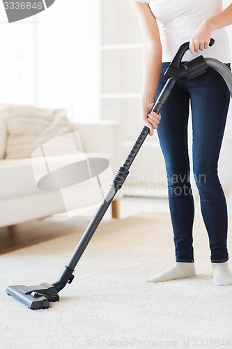 Image of close up of woman with vacuum cleaner at home