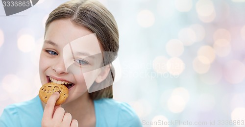 Image of smiling little girl eating cookie or biscuit