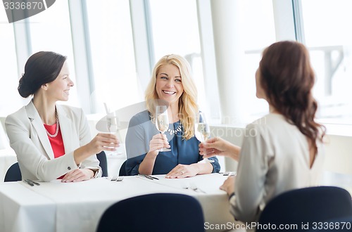 Image of happy women drinking champagne at restaurant