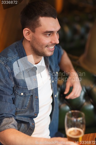 Image of happy man drinking beer at bar or pub