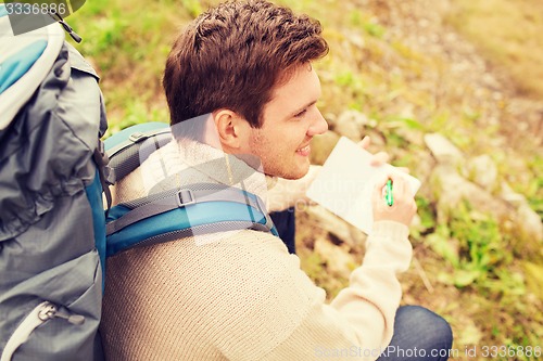 Image of smiling man with backpack hiking