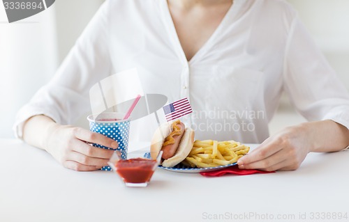 Image of close up of woman eating hotdog and french fries