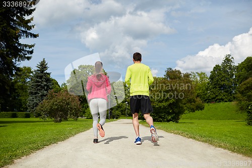 Image of smiling couple running outdoors