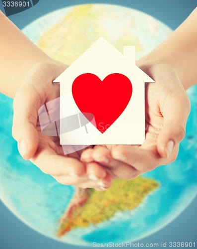 Image of human hands holding paper house with red heart