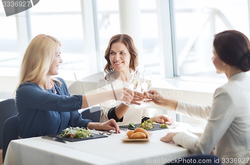 Image of happy women drinking champagne at restaurant