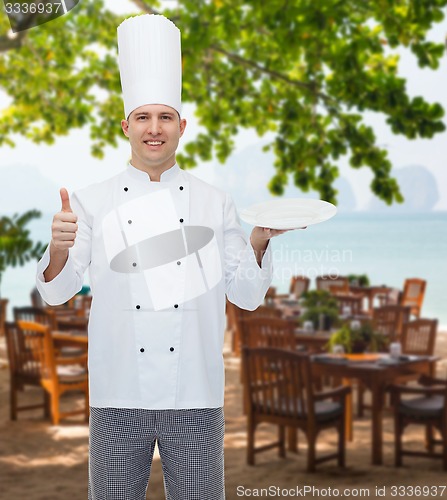 Image of happy male chef cook showing thumbs up and plate