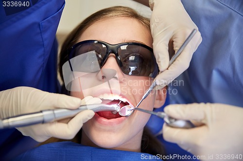 Image of female dentists treating patient girl teeth
