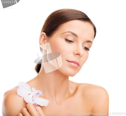 Image of relaxed woman with orhid flower