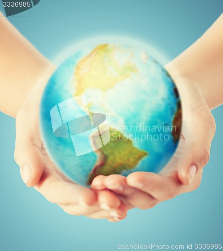 Image of close up of human hands with earth globe