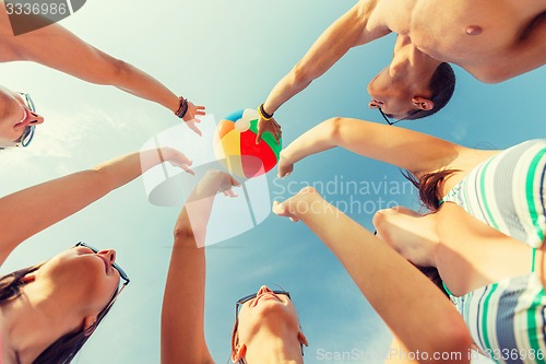 Image of smiling friends in circle on summer beach