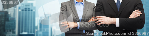 Image of businesswoman and businessman with crossed arms