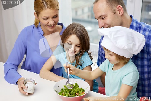 Image of happy family with two kids cooking at home