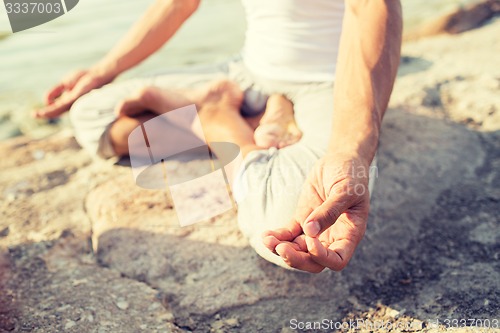 Image of close up of man making yoga exercises outdoors