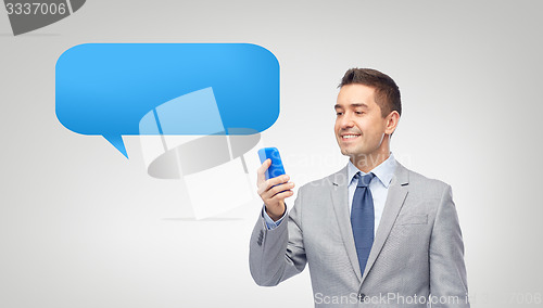 Image of happy businessman texting message on smartphone