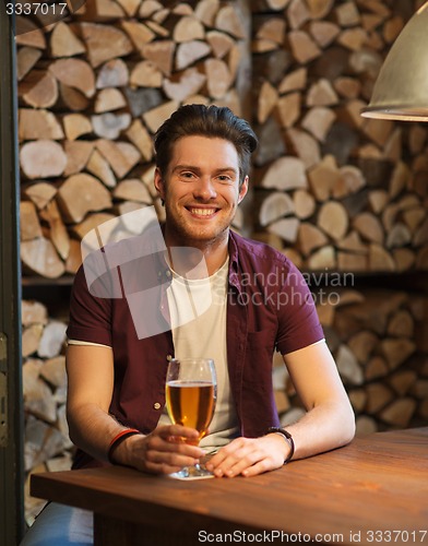 Image of happy man drinking beer at bar or pub