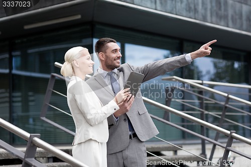 Image of smiling businessmen with tablet pc outdoors