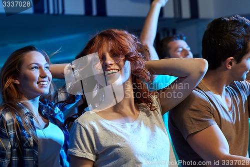 Image of happy friends dancing at night club