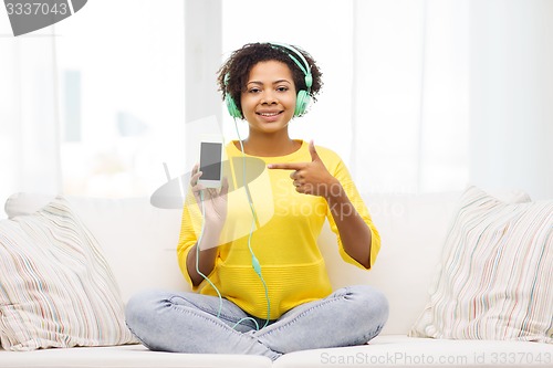 Image of happy african woman with smartphone and headphones
