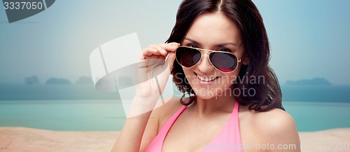 Image of happy woman in sunglasses and swimsuit