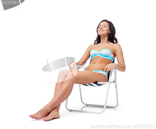 Image of happy young woman sunbathing in bikini swimsuit