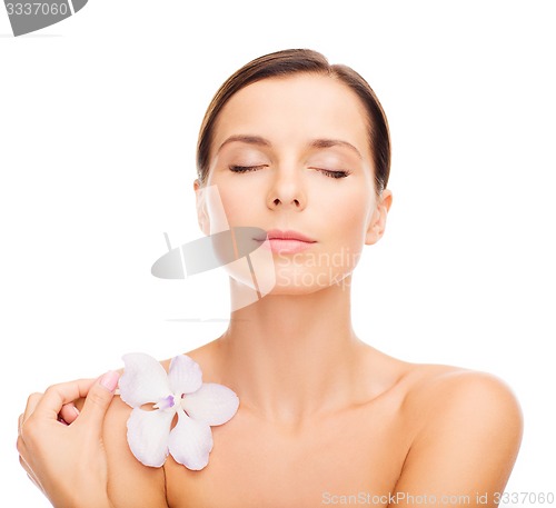 Image of relaxed woman with orhid flower