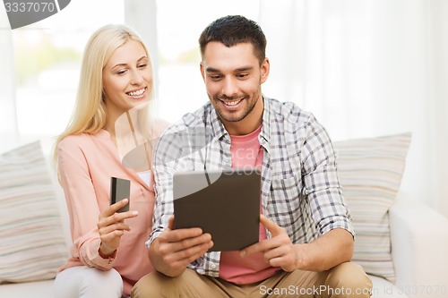 Image of happy couple with tablet pc and credit card