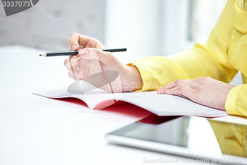 Image of close up of female hands writing to notebook