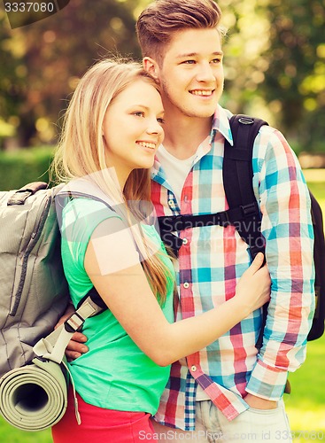 Image of smiling couple with backpacks in nature