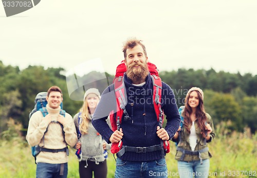 Image of group of smiling friends with backpacks hiking