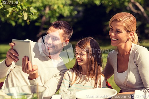 Image of happy family with tablet pc outdoors