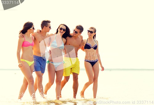 Image of smiling friends in sunglasses on summer beach