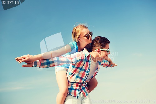 Image of smiling couple having fun outdoors