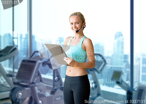 Image of happy woman trainer with microphone and clipboard