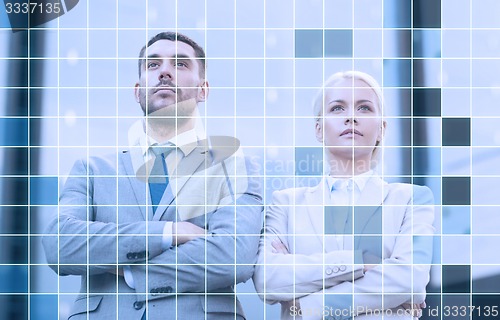 Image of serious businessmen standing over office building