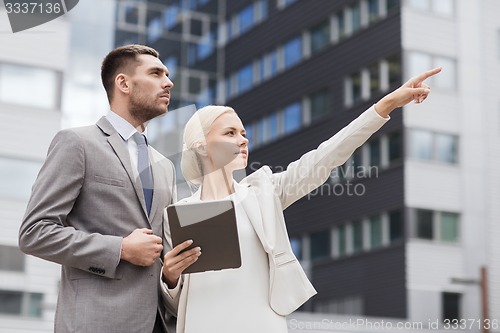 Image of serious businessmen with tablet pc outdoors