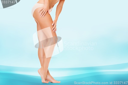 Image of woman in cotton panties touching her legs