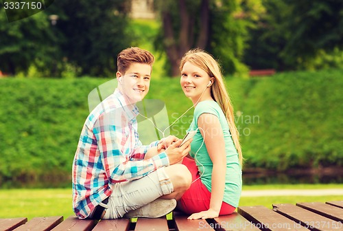 Image of smiling couple with smartphone and earphones