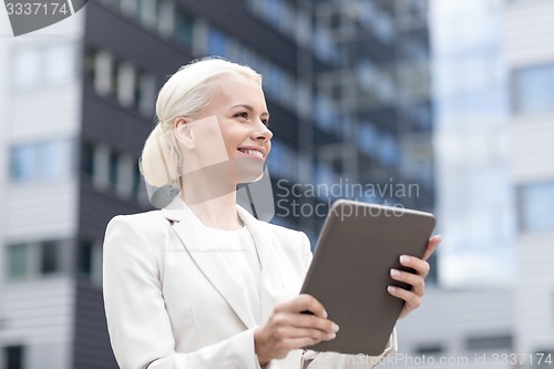 Image of smiling businesswoman with tablet pc outdoors