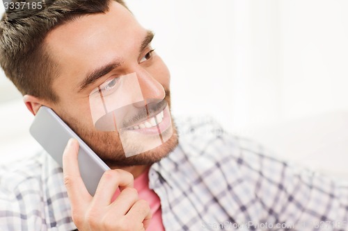 Image of smiling young man calling on smartphone