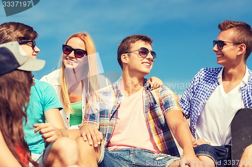 Image of group of smiling friends sitting on city street