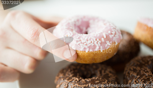 Image of close up of hand holding glazed donut