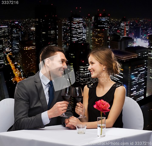 Image of young couple with glasses of wine at restaurant