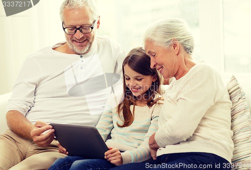 Image of smiling family with tablet pc at home