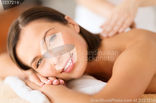 Image of beautiful woman in spa salon getting massage