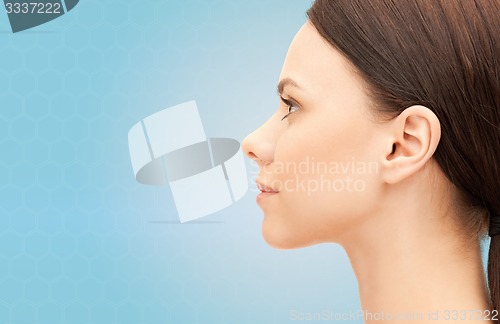 Image of beautiful young woman face over blue background