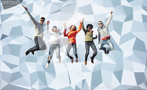 Image of smiling friends in sunglasses jumping high