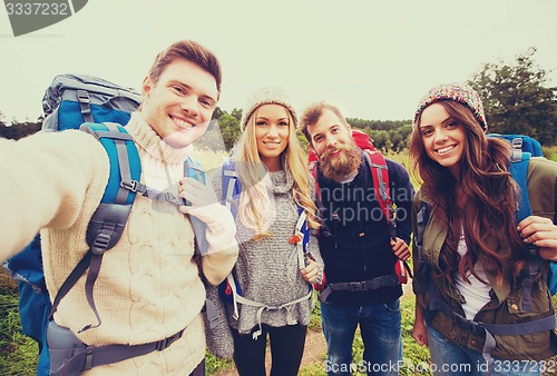 Image of group of smiling friends with backpacks hiking