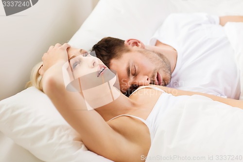 Image of couple sleeping in bed at home