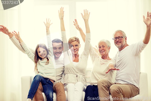 Image of happy family sitting on sofa at home